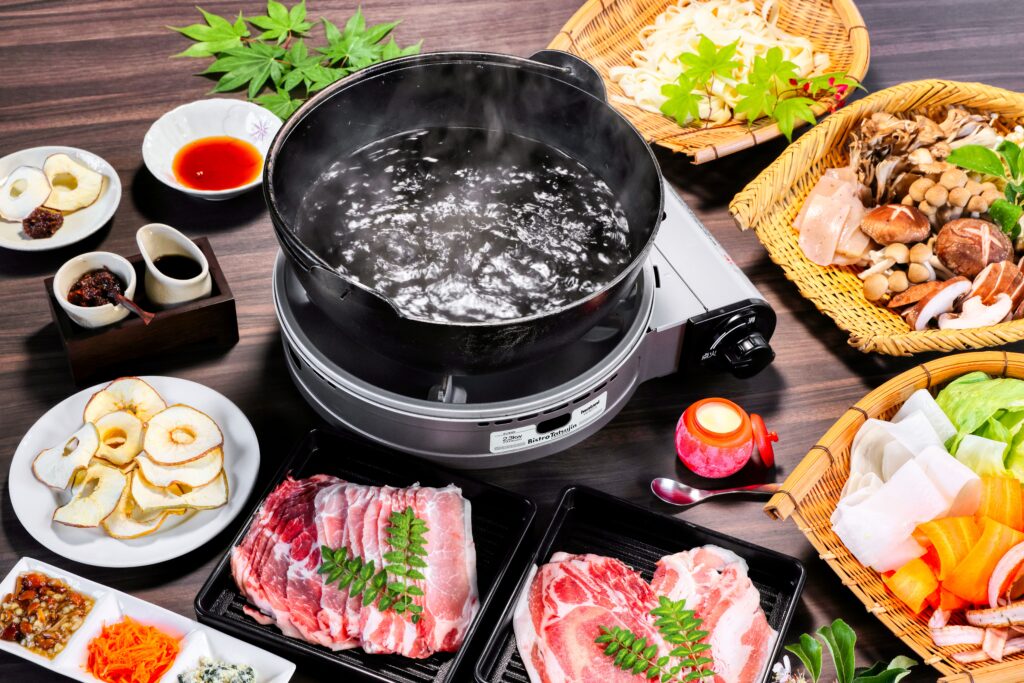 肉や野菜、りんごを並べたしゃぶしゃぶの食事例